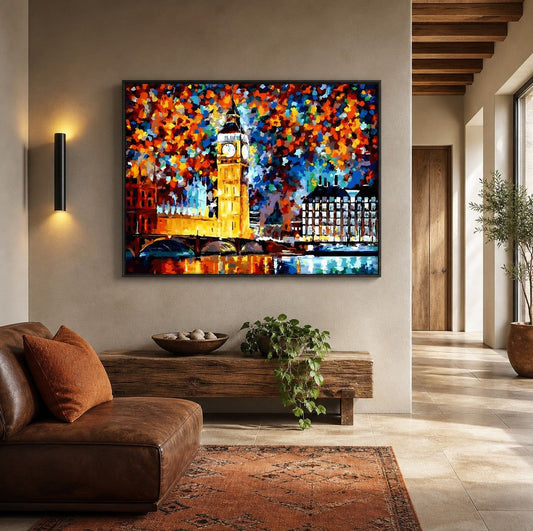 Colourful hand-painted textured cityscape canvas hung above a low wooden console table in a warm, light-filled living room with a leather sofa