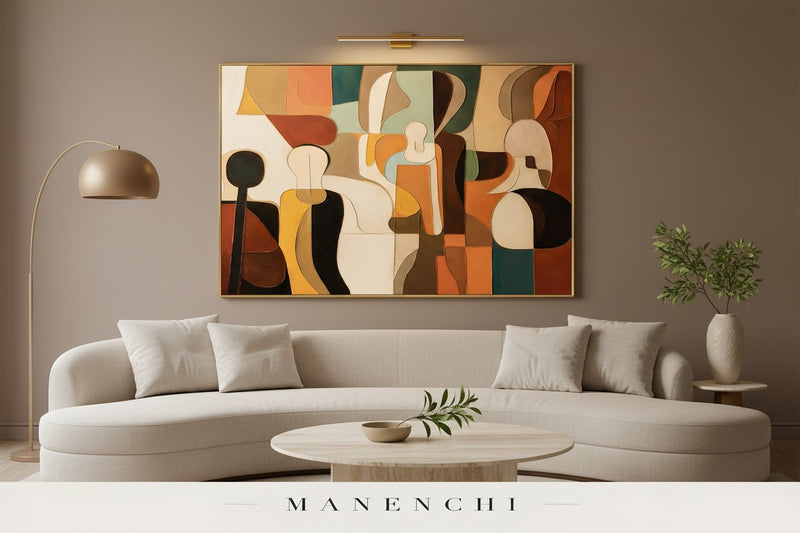 A large framed abstract canvas wall art with warm geometric shapes in beige, brown, orange, cream, and teal, displayed on a taupe wall above a modern curved white sofa in a styled living room.